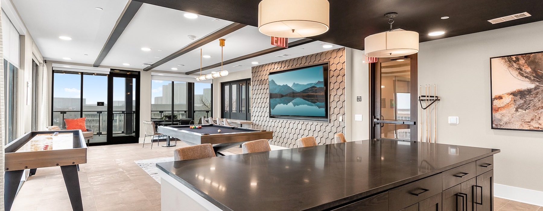 a clubroom with a table, chairs and game tables